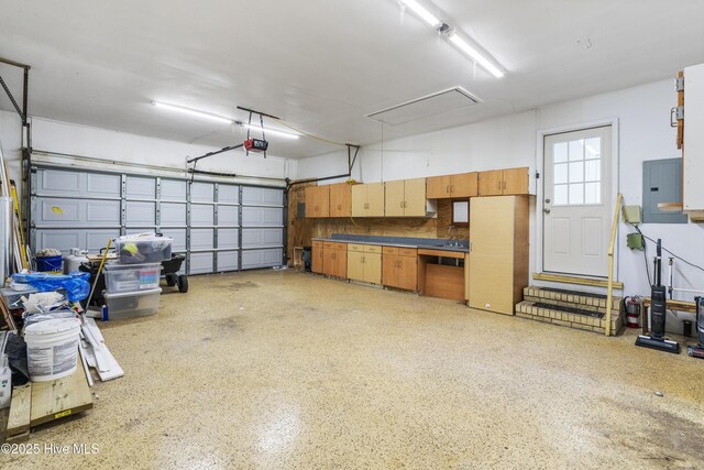 garage with electric panel and a garage door opener