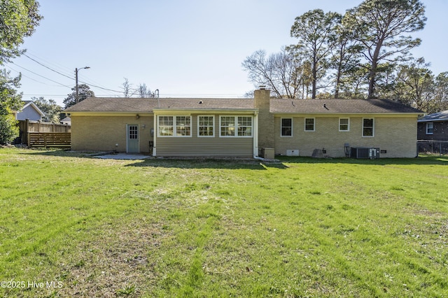 rear view of property featuring a yard and cooling unit