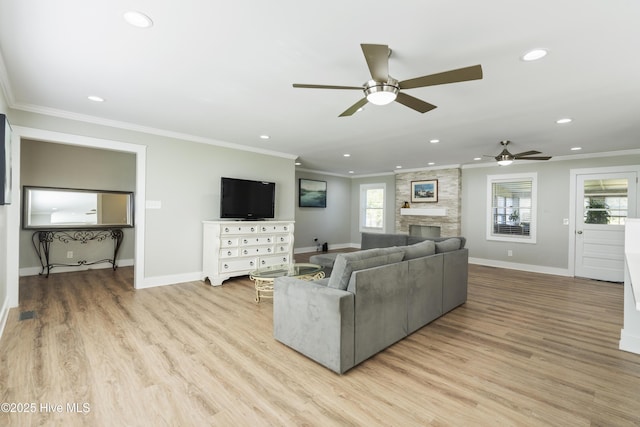 living room featuring ceiling fan, a healthy amount of sunlight, light wood-type flooring, and crown molding