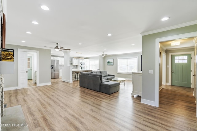 living room featuring ceiling fan, light hardwood / wood-style flooring, and ornamental molding