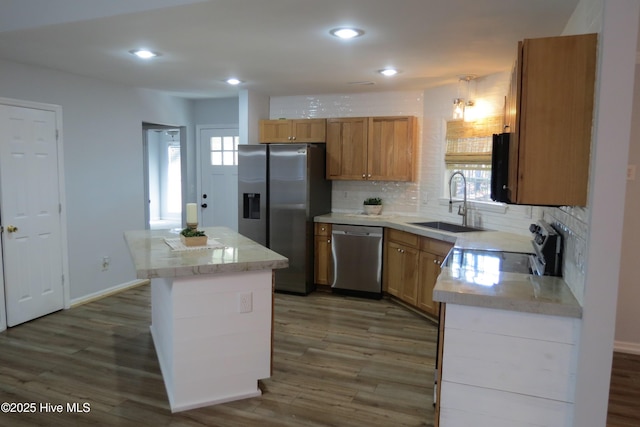 kitchen with tasteful backsplash, stainless steel appliances, sink, dark hardwood / wood-style floors, and a kitchen island