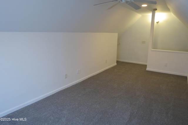 additional living space featuring dark carpet, ceiling fan, and lofted ceiling