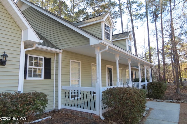 view of side of property featuring covered porch