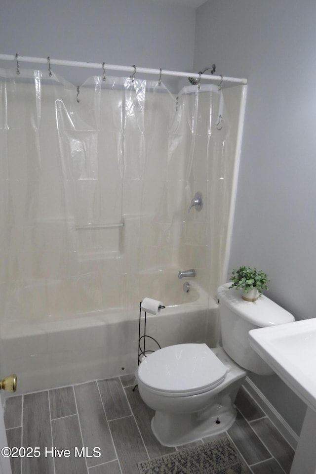 bathroom with toilet and shower / tub combo