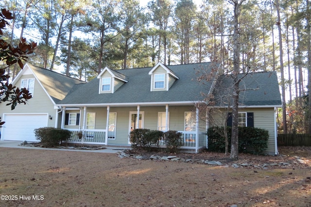 new england style home featuring covered porch and a garage