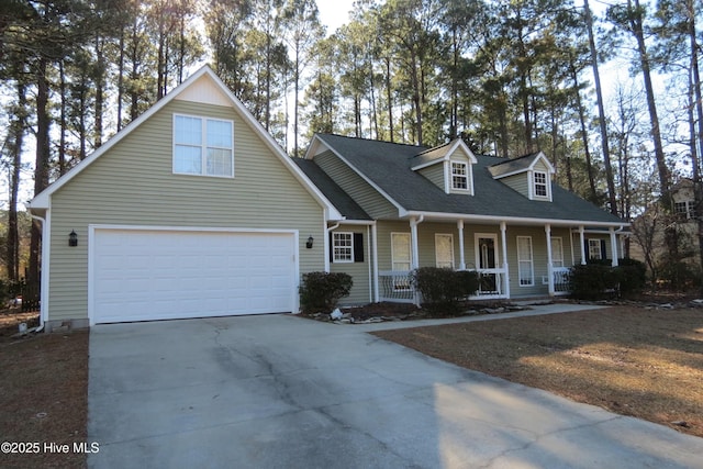 cape cod home featuring a garage and covered porch