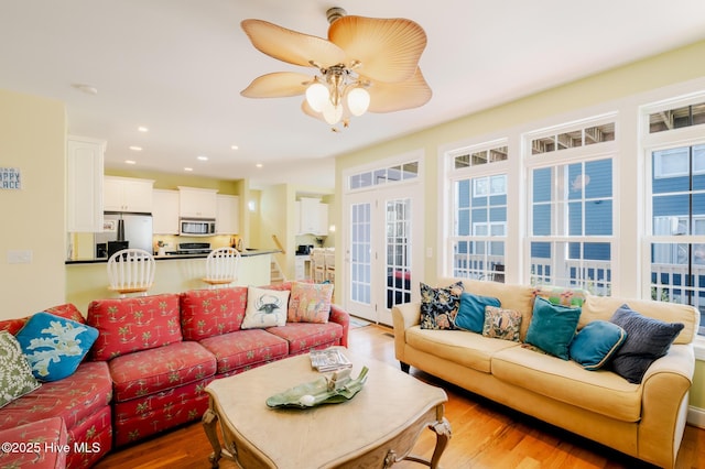 living room featuring hardwood / wood-style floors, ceiling fan, and french doors