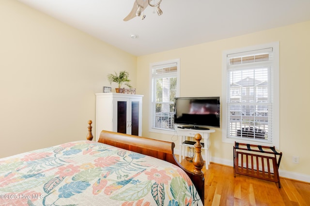 bedroom featuring light hardwood / wood-style floors, multiple windows, and ceiling fan