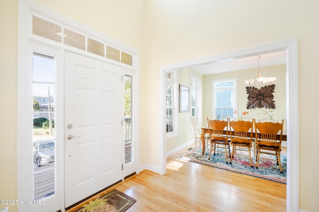 foyer entrance featuring light wood-type flooring and a notable chandelier