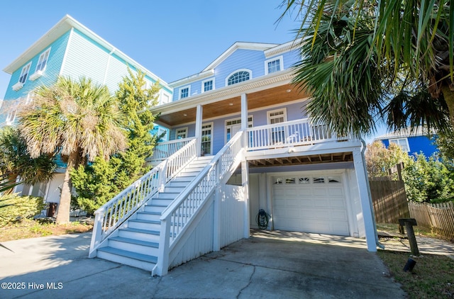 raised beach house featuring a porch and a garage