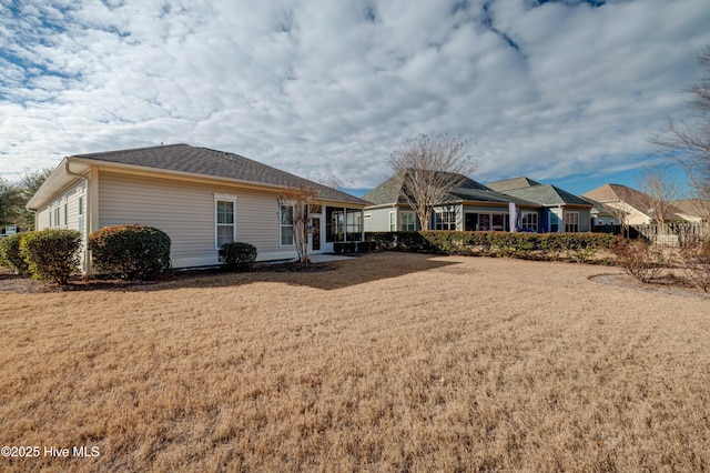 rear view of house with a sunroom and a yard