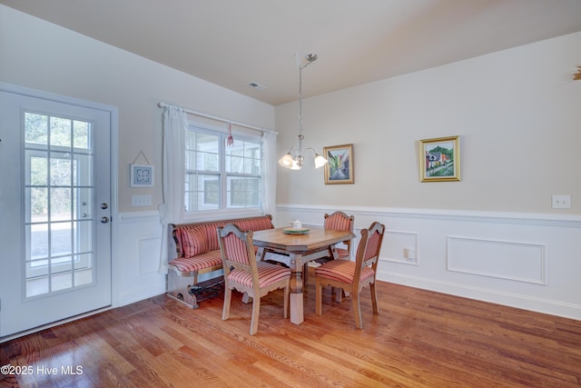 dining area featuring wood-type flooring and an inviting chandelier