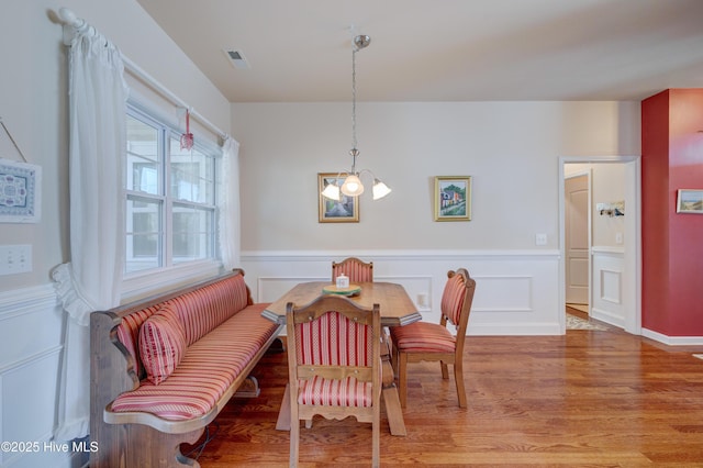 dining area with wood-type flooring and a notable chandelier