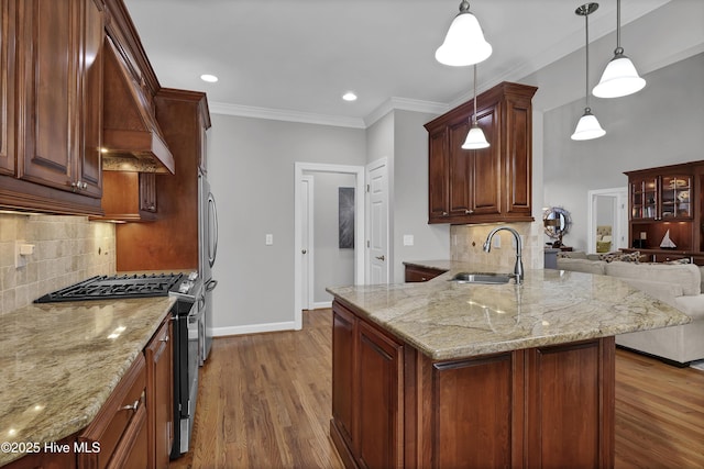 kitchen featuring sink, hanging light fixtures, stainless steel appliances, ornamental molding, and hardwood / wood-style flooring