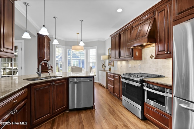 kitchen featuring sink, hanging light fixtures, light stone counters, appliances with stainless steel finishes, and custom exhaust hood