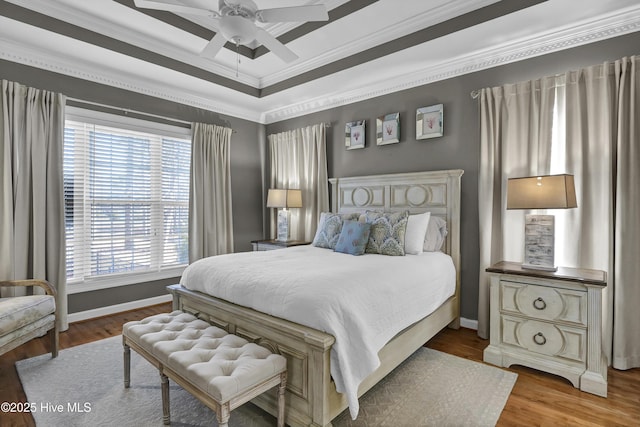 bedroom featuring multiple windows, hardwood / wood-style floors, ceiling fan, and crown molding