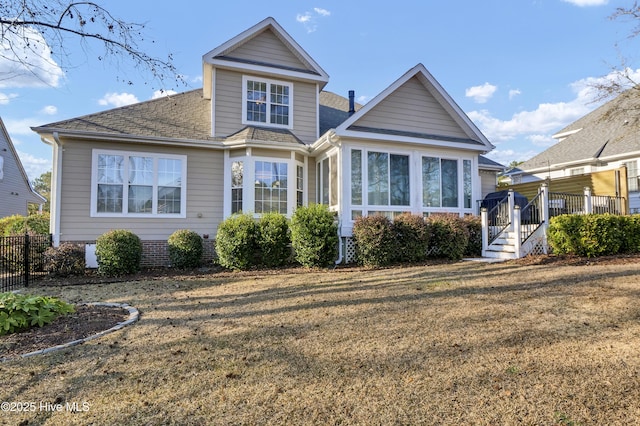 view of front of property featuring a sunroom and a front yard