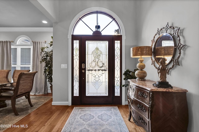 foyer with crown molding and light wood-type flooring