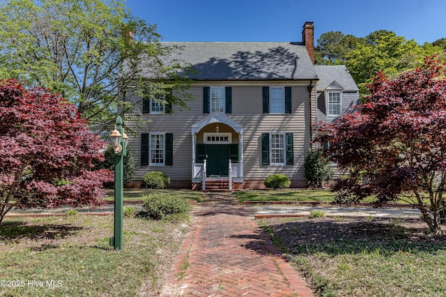 colonial house with a chimney and a front lawn