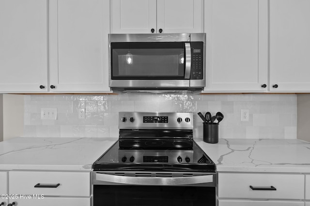 kitchen featuring white cabinets, decorative backsplash, and stainless steel appliances