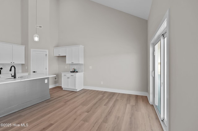 kitchen featuring white cabinets, sink, and high vaulted ceiling