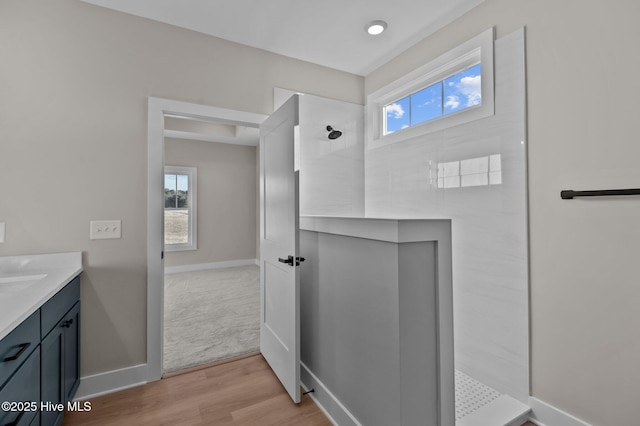 bathroom featuring a shower, wood-type flooring, and vanity