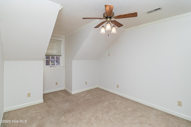 additional living space with ceiling fan, lofted ceiling, light carpet, and a textured ceiling