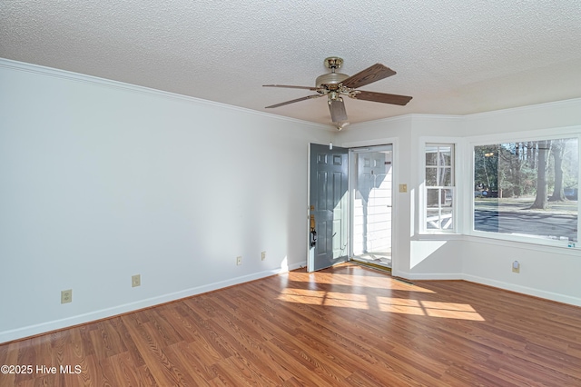 unfurnished room featuring wood-type flooring, ornamental molding, ceiling fan, and a textured ceiling