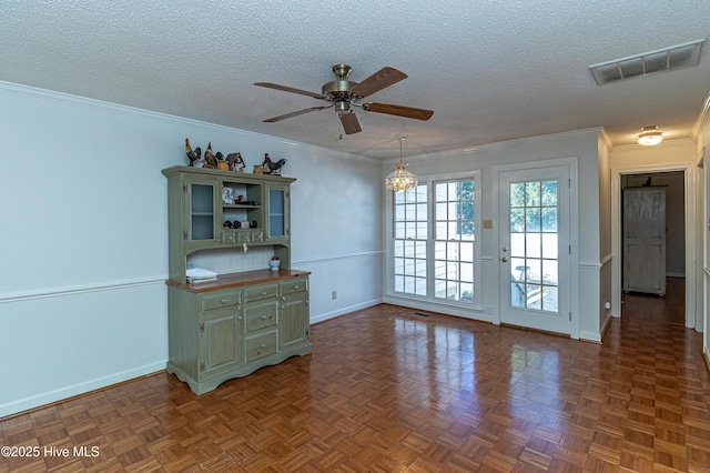 interior space featuring ceiling fan, dark parquet flooring, ornamental molding, and a textured ceiling