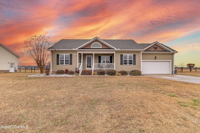 ranch-style home featuring a garage, a lawn, and covered porch