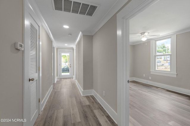 hall featuring a wealth of natural light, light hardwood / wood-style flooring, and crown molding