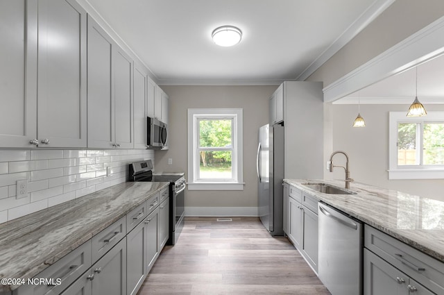 kitchen with stainless steel appliances, gray cabinets, ornamental molding, and sink