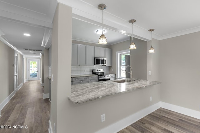 kitchen with pendant lighting, backsplash, sink, kitchen peninsula, and stainless steel appliances