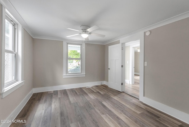 spare room featuring light wood-type flooring, ceiling fan, and crown molding