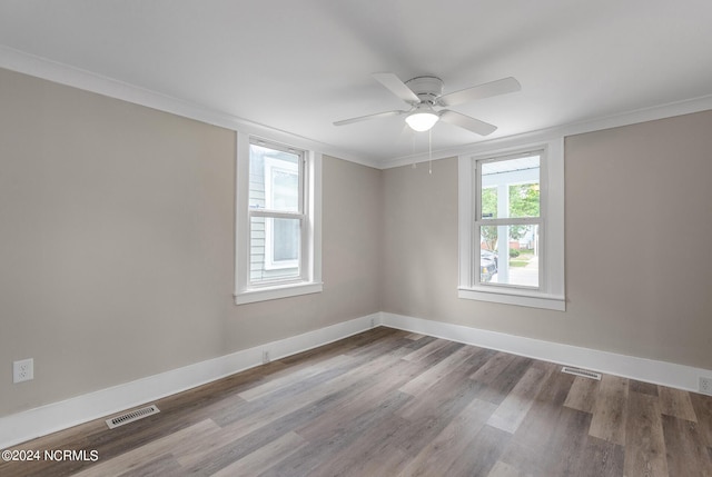 empty room featuring wood-type flooring, ceiling fan, and ornamental molding