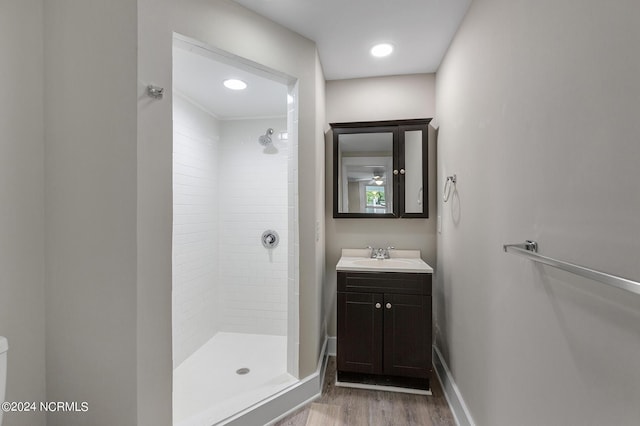 bathroom featuring tiled shower, vanity, and hardwood / wood-style flooring