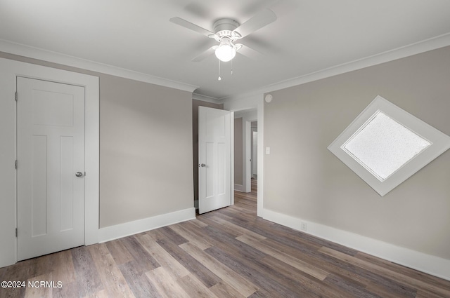 unfurnished bedroom featuring hardwood / wood-style floors, a closet, ceiling fan, and ornamental molding