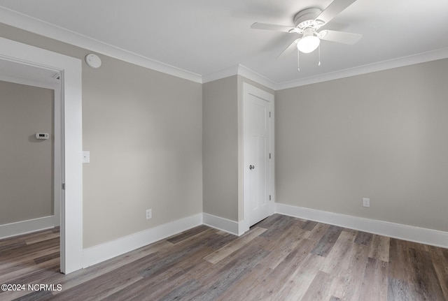 empty room featuring wood-type flooring, ceiling fan, and ornamental molding