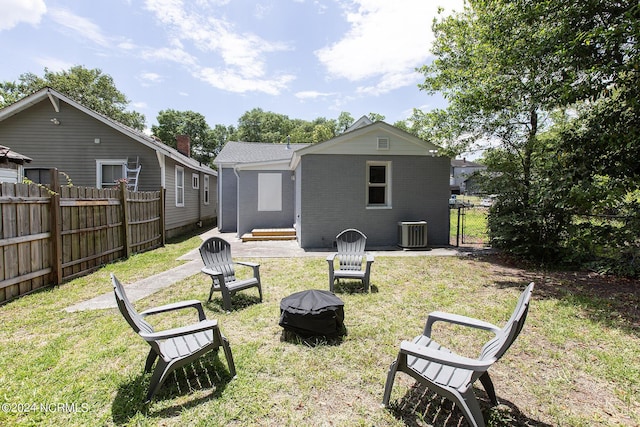 back of house with cooling unit and a yard