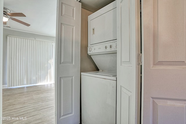 laundry area featuring ceiling fan, light hardwood / wood-style flooring, and stacked washer and clothes dryer