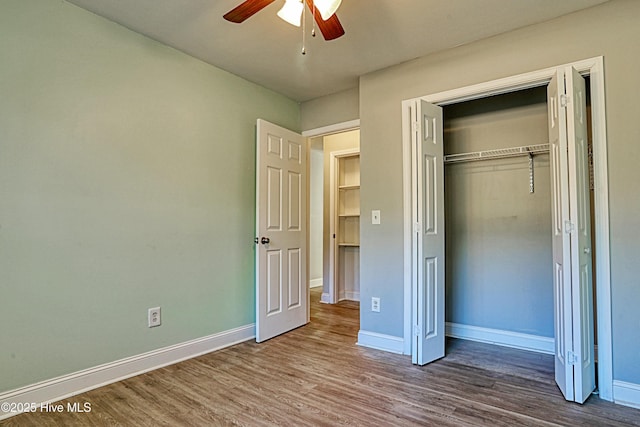 unfurnished bedroom featuring ceiling fan, wood-type flooring, and a closet