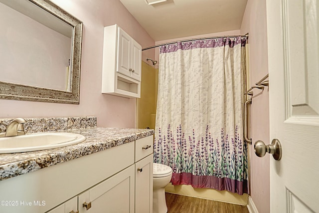 full bathroom featuring hardwood / wood-style flooring, vanity, toilet, and shower / bathtub combination with curtain