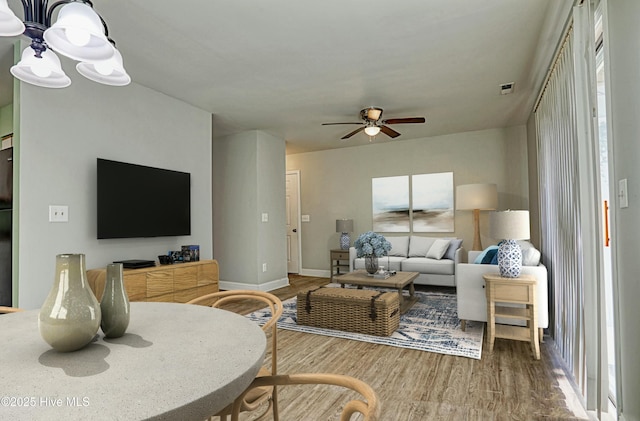 living room with ceiling fan and wood-type flooring