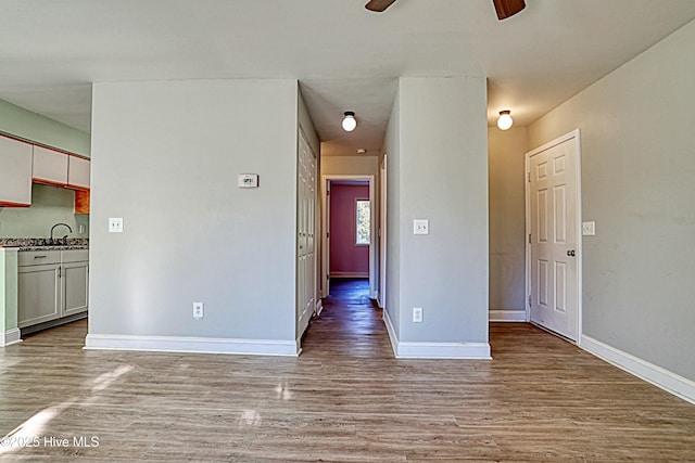 empty room with ceiling fan, light hardwood / wood-style floors, and sink