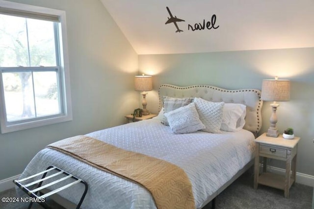 bedroom with multiple windows, dark carpet, and lofted ceiling