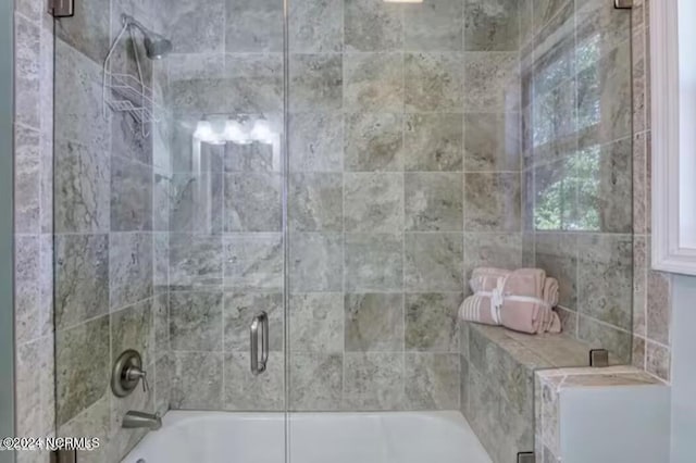 bathroom featuring shower / bath combination with glass door