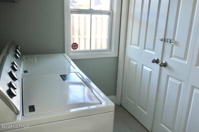 laundry room featuring light tile patterned flooring and washing machine and clothes dryer