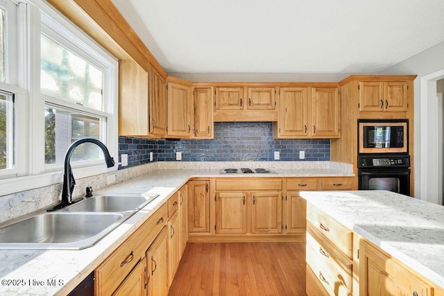 kitchen with backsplash, oven, built in microwave, and sink