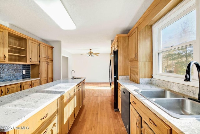 kitchen with decorative backsplash, black refrigerator, sink, and dishwashing machine