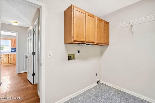 laundry area with cabinets, washer hookup, a textured ceiling, and hookup for an electric dryer